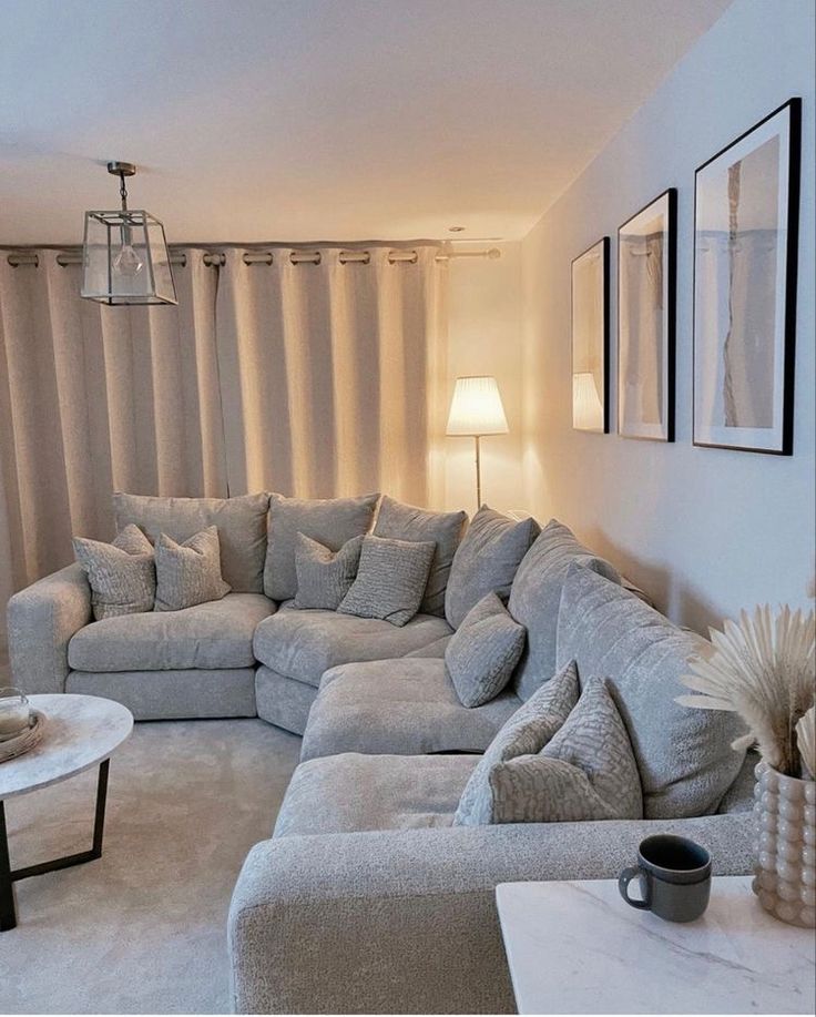 a living room filled with lots of furniture next to a wall covered in pictures and curtains