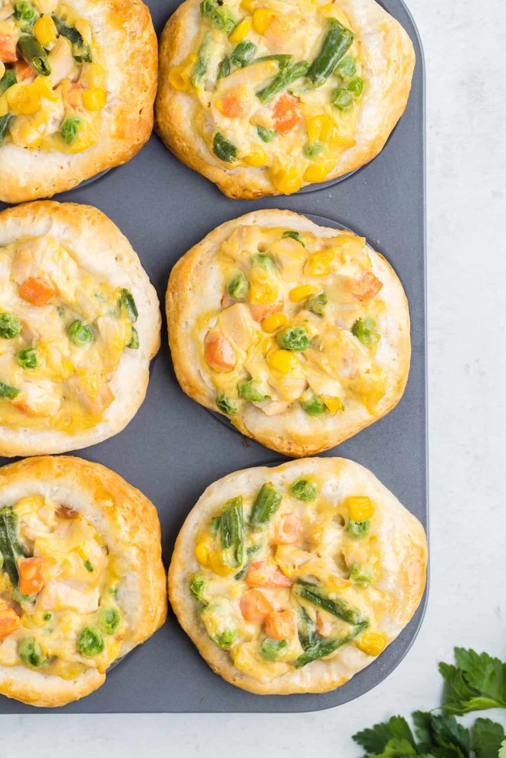 six small muffins with vegetables and cheese on top