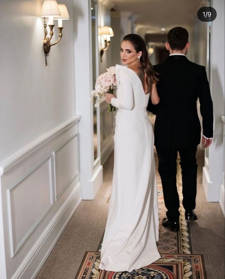 the bride and groom are walking down the hallway