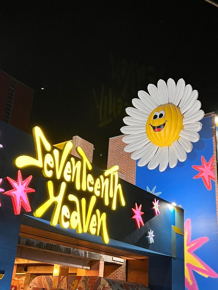 a neon sign that says seventh heaven with a smiley face on it