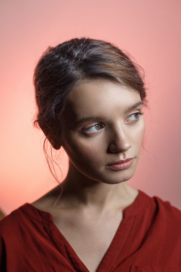 a woman in a red shirt is looking at the camera