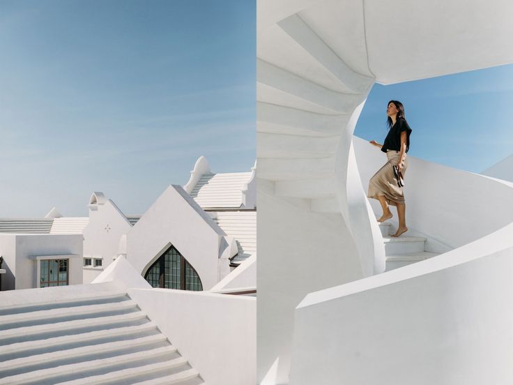 a woman standing on the top of a white staircase next to a building with stairs