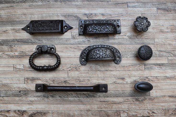 an assortment of antique door handles and knobs on a wooden floor with wood planking