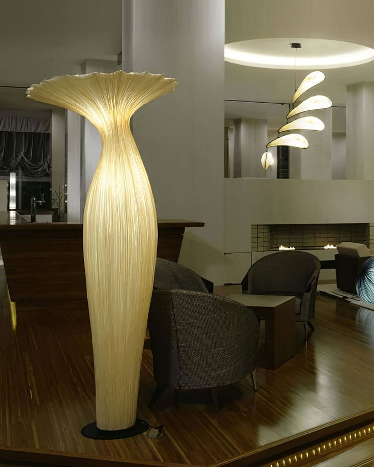 a large floor lamp sitting on top of a hard wood floor next to a living room