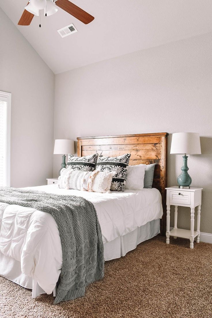 a bedroom with a bed, nightstands and ceiling fan in the middle of it