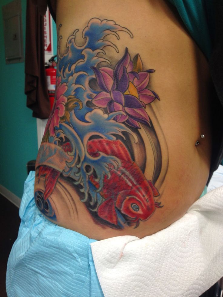 a woman with a tattoo on her stomach has a koi fish in the water