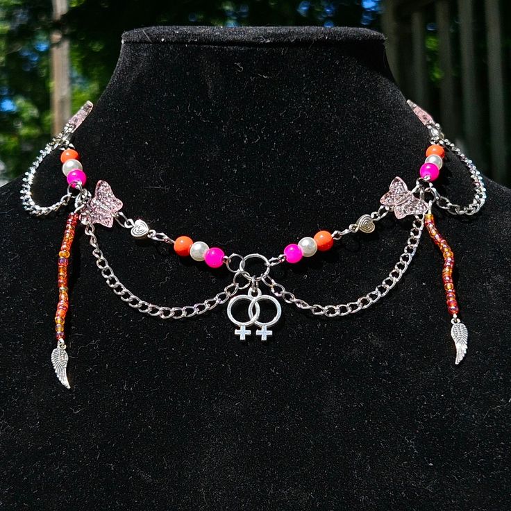 a black mannequin with various colored beads and charms on it's neck