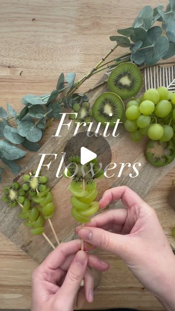 a person cutting grapes on a wooden board with the words fruit florers above it