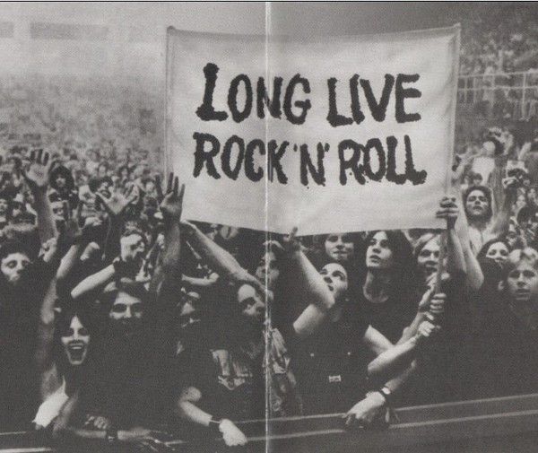 a group of people holding up a sign that says long live rock'n'roll