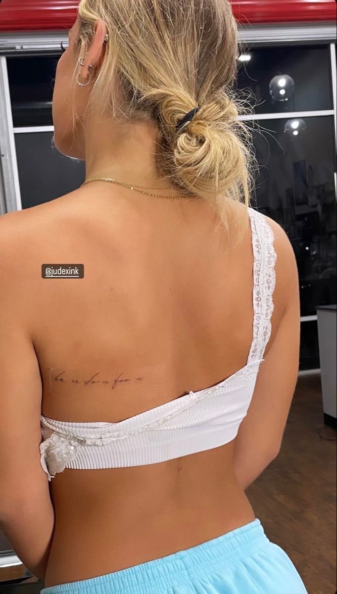 the back of a woman's bra showing her small tattoo on her left shoulder