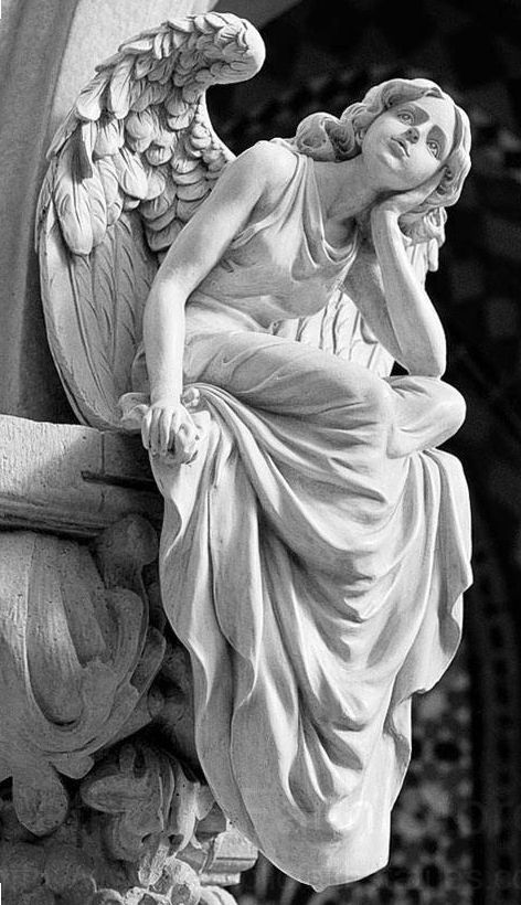 an angel statue sitting on top of a pillar