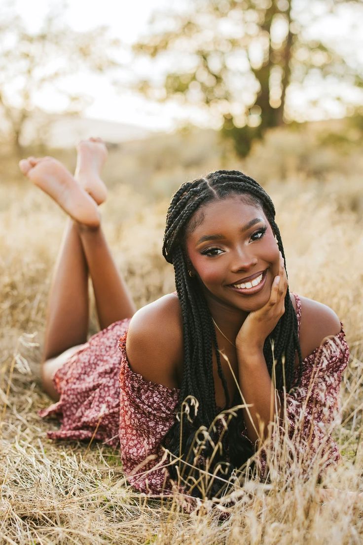 a woman laying in the grass smiling at the camera