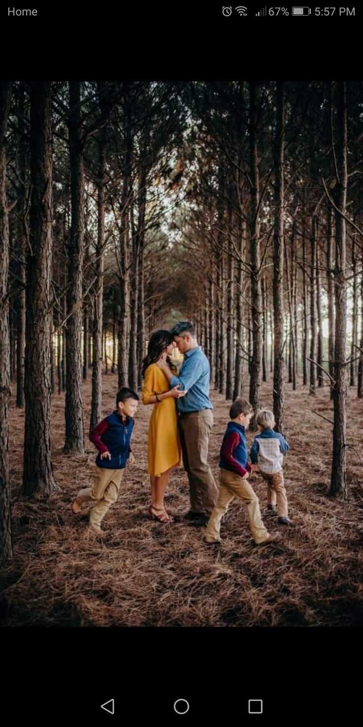 a man and woman are kissing in the woods with two children on their backs as they stand