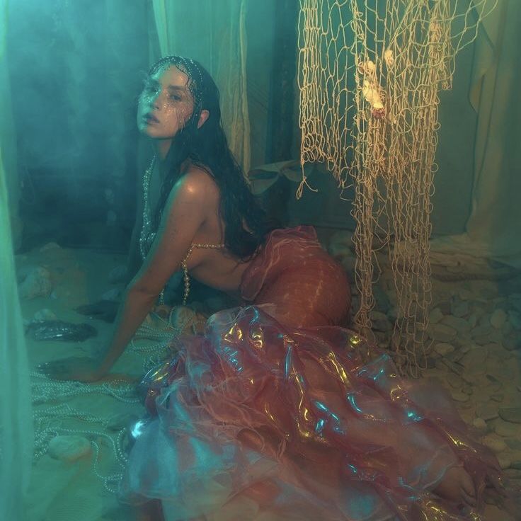 a woman is sitting on the ground in a room with plastic wrap around her body