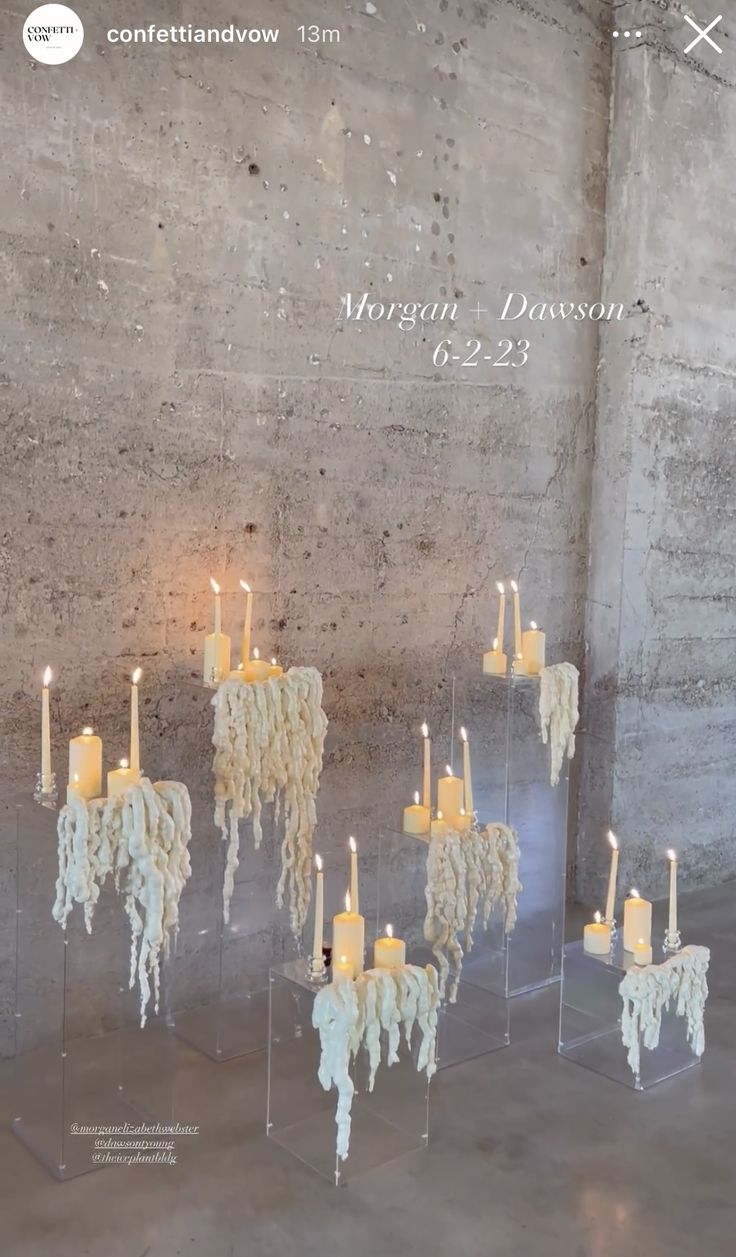 a group of candles that are sitting in the middle of a room with concrete walls