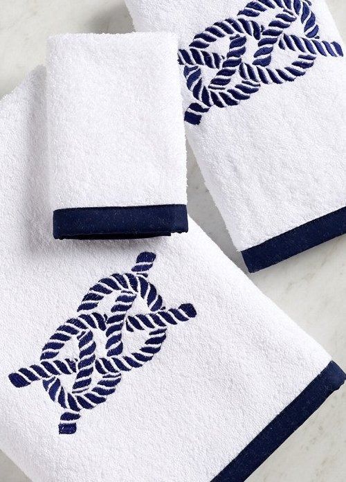 three white towels with blue trim on them sitting on a marble counter top next to each other