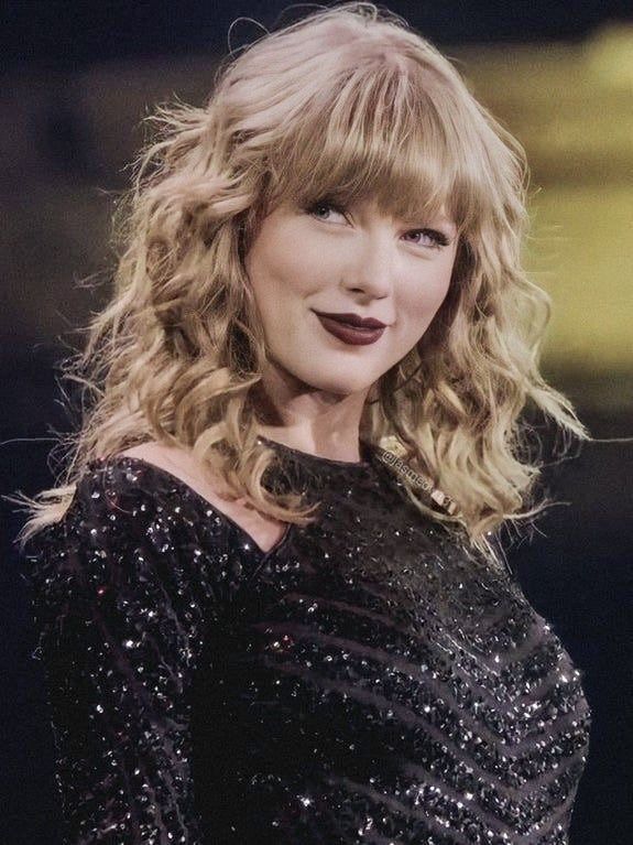 a woman with blonde hair wearing a black dress and smiling at the camera while standing in front of a microphone