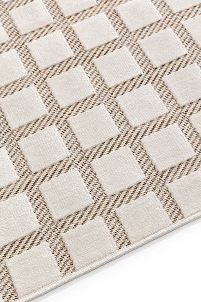 an area rug with squares and lines on the floor, in neutral colors or beiges