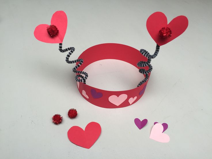 a paper bracelet with hearts attached to it and some other decorations around the wristband