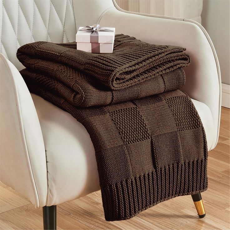 a chair with a blanket and gift wrapped in brown