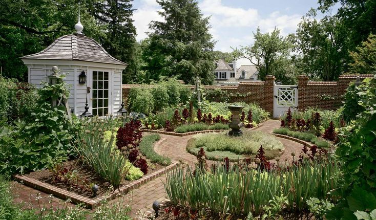 a garden with lots of plants and flowers in the center, surrounded by greenery