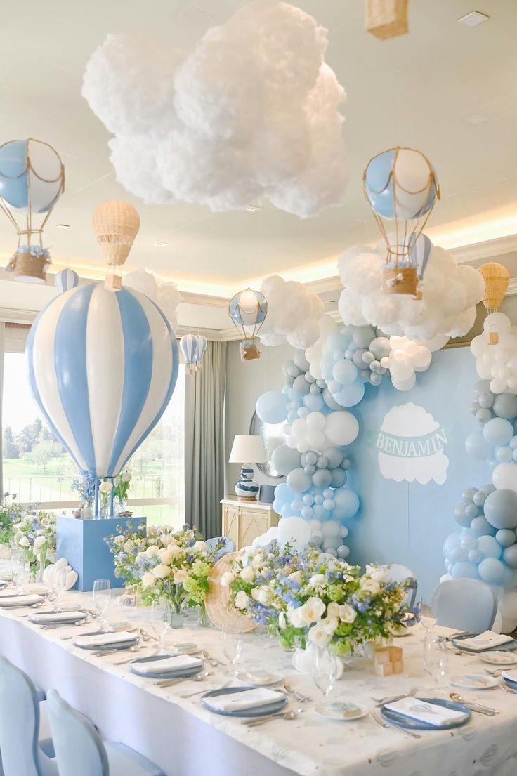 a table set up for a baby's first birthday party with balloons and decorations