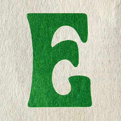 the letter c is made up of green grass and white paper with a black outline