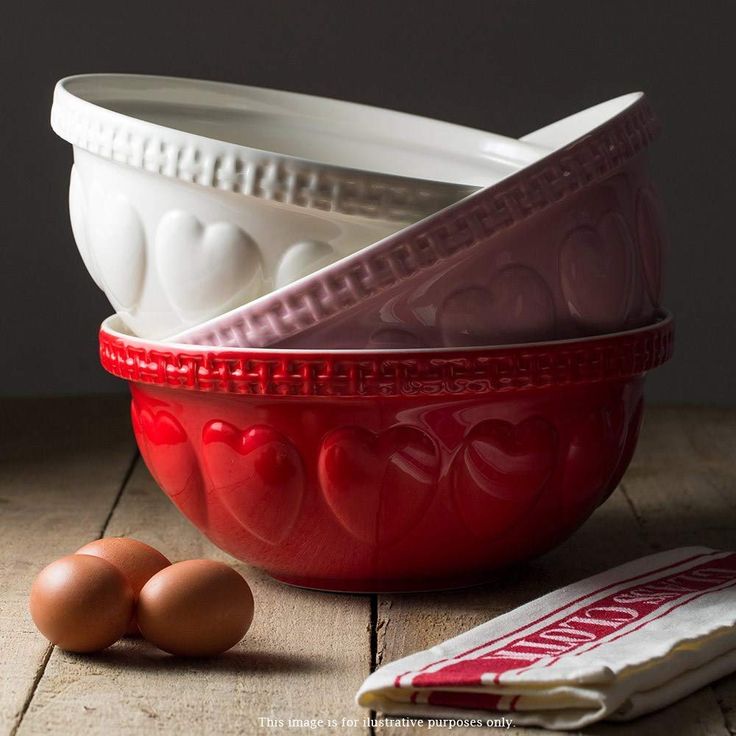 three bowls and two eggs on a wooden table