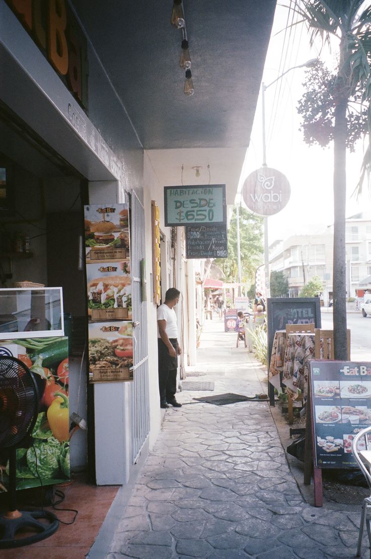 a man is standing in the doorway of a restaurant