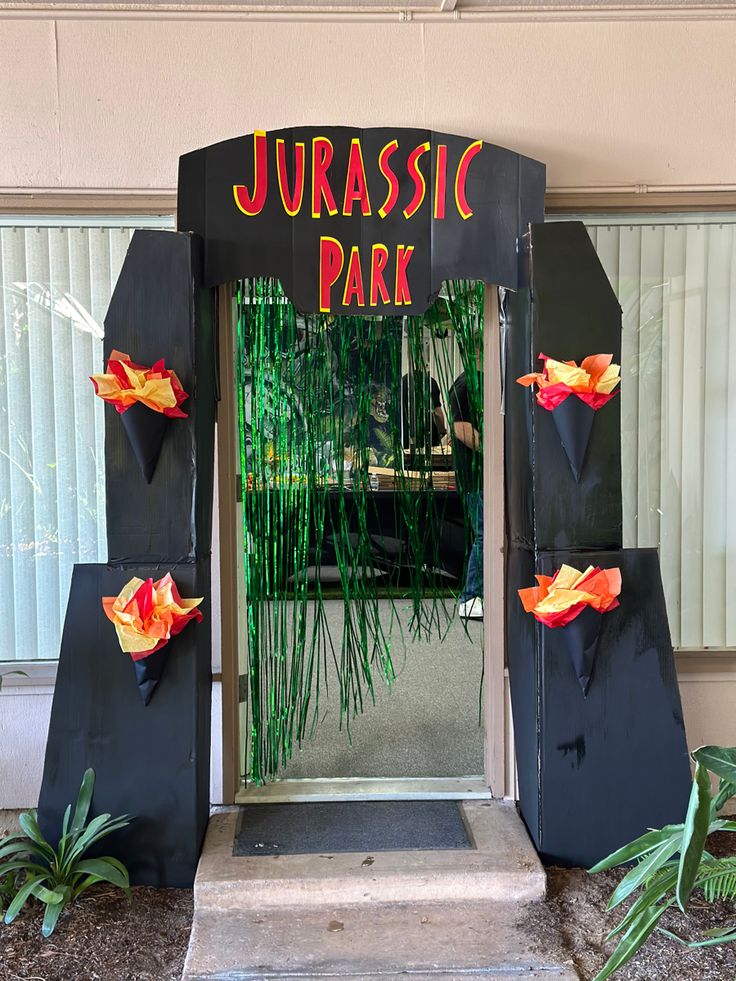 an entrance to a tropical park with fake flowers on the front door and in the back