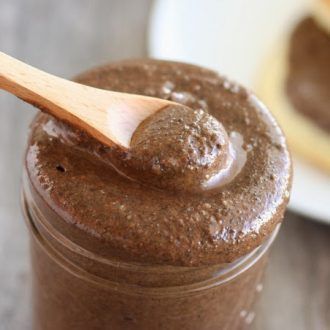 a jar filled with chocolate spread and a wooden spoon