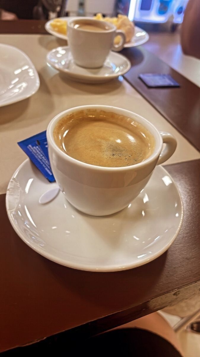 a cup of coffee sitting on top of a white saucer