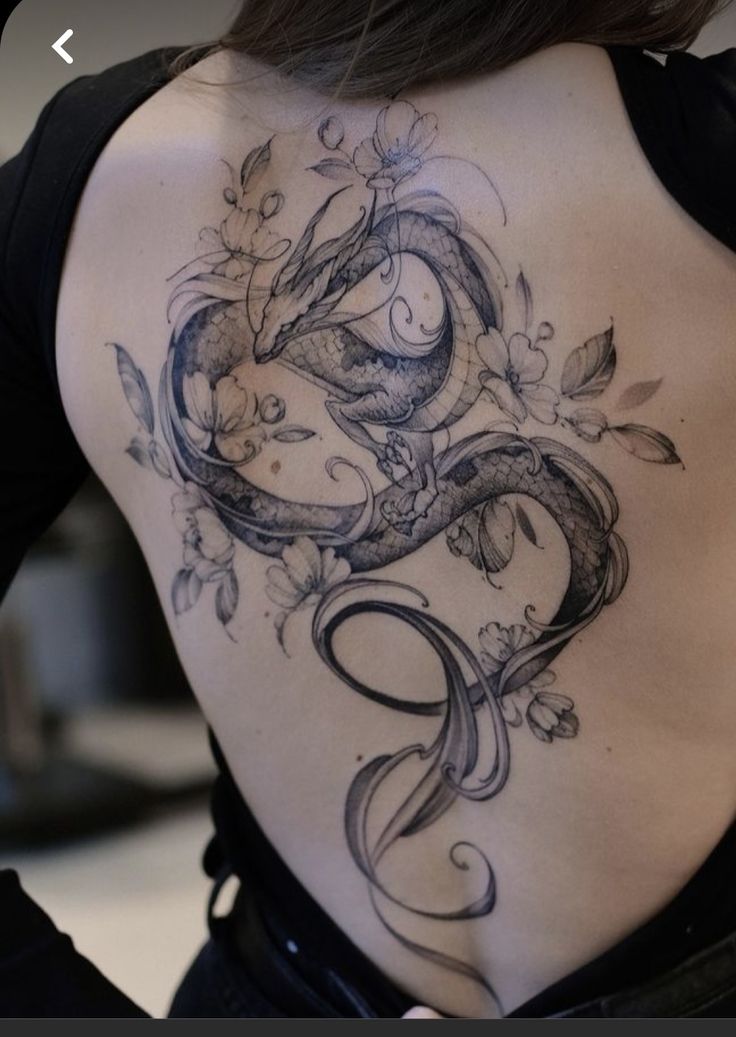 the back of a woman's body with tattoos on it