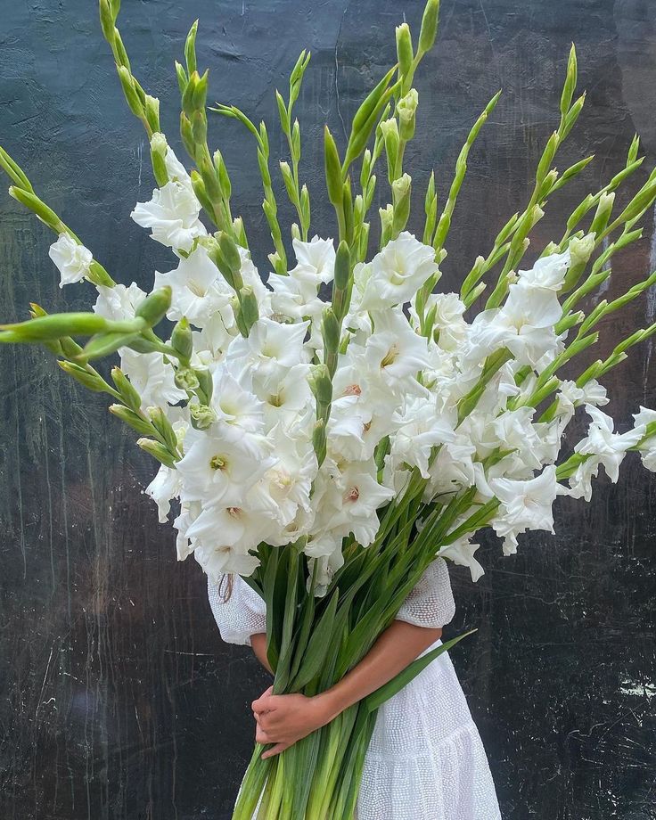 a woman holding a bouquet of white flowers