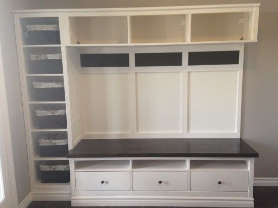 an empty room with white shelves and drawers