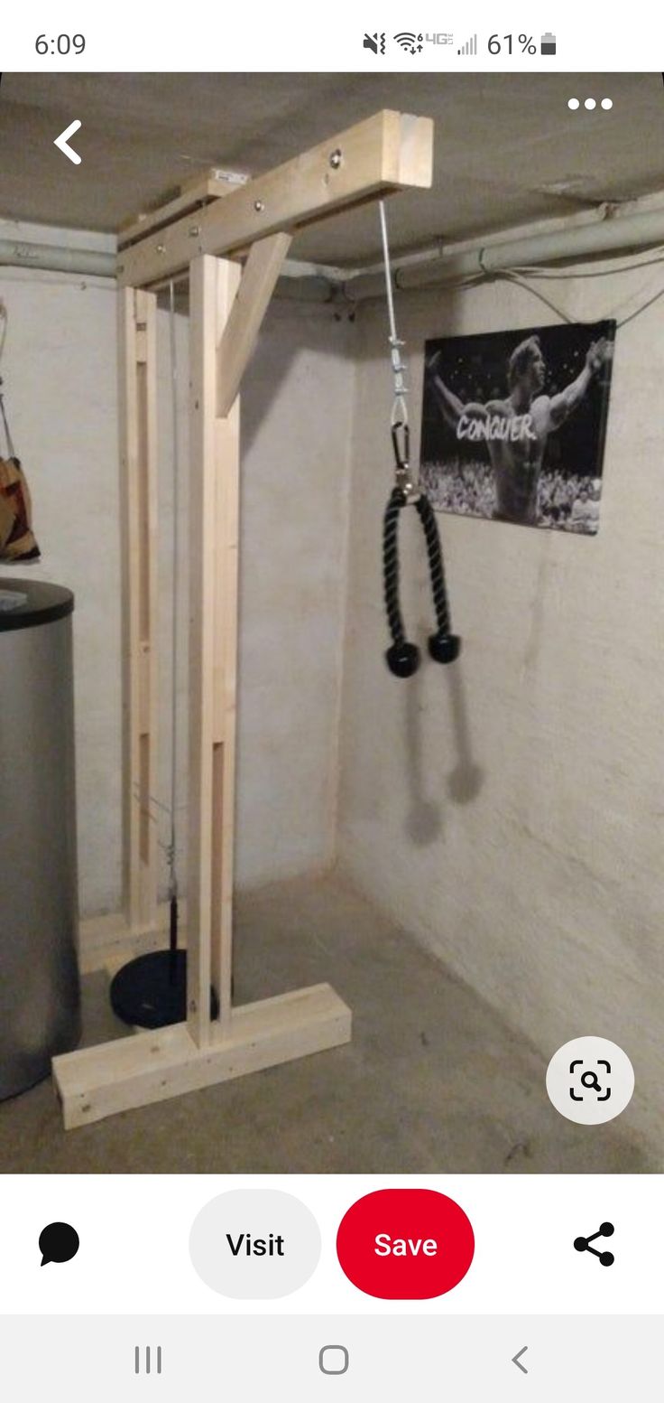 a gym room with an overhead pull up bar and metal trash can in the corner