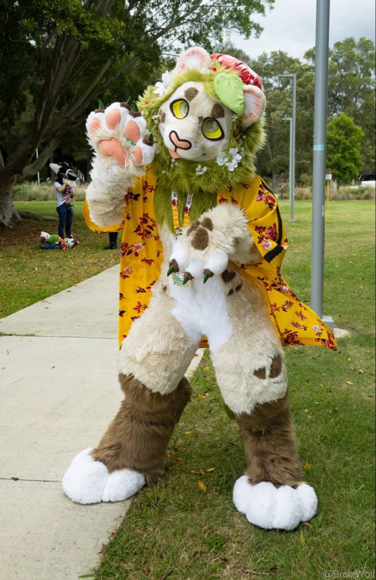 a person in a costume standing on the sidewalk with a stuffed animal next to him