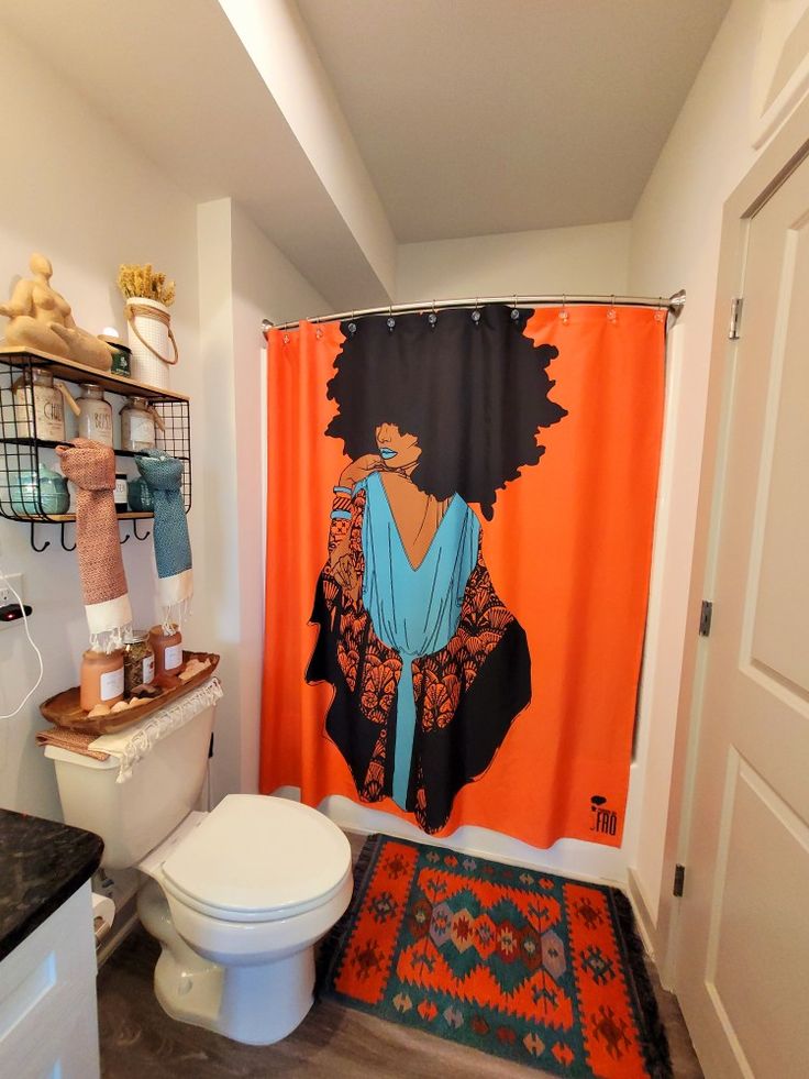 a bathroom with an orange shower curtain and rug