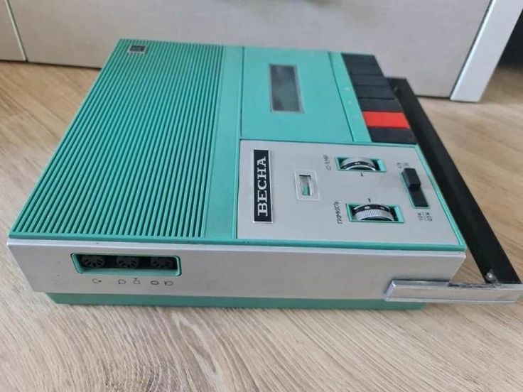 an electronic device sitting on top of a wooden floor next to a drawer filled with wires