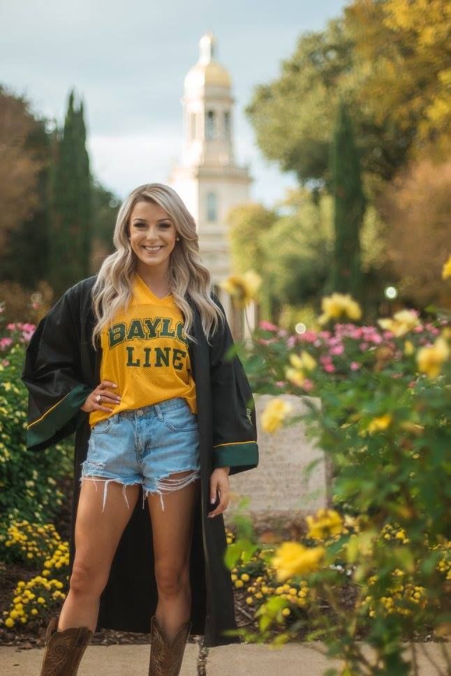 a young woman is standing in front of flowers and trees wearing a t - shirt that says bayly line