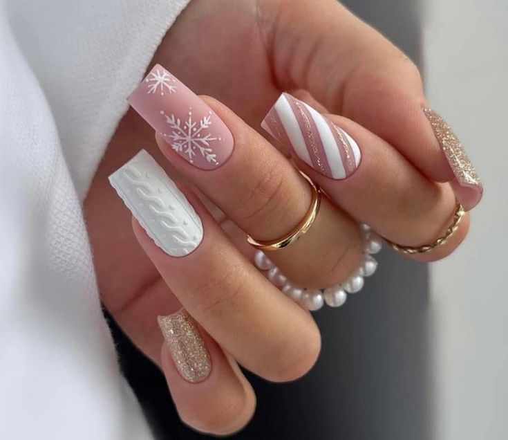 a woman's hand with some white and gold nail polishes on her nails