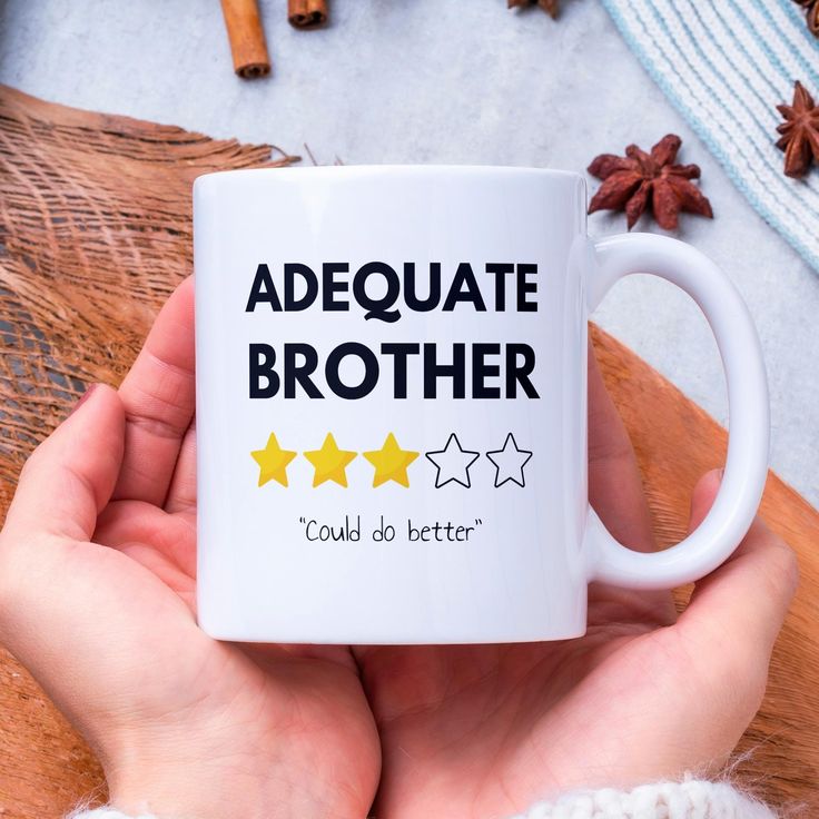 a person holding a coffee mug with five stars on it and the words,'adequate brother could do better '