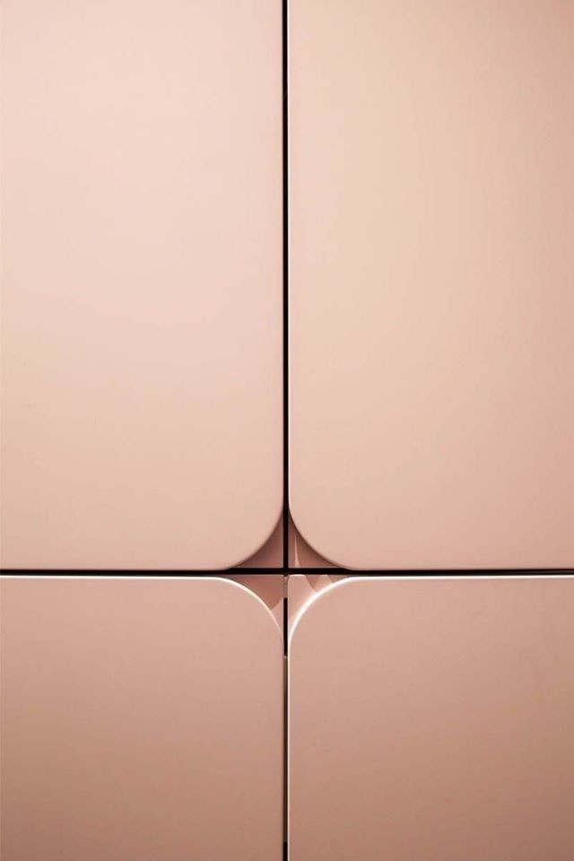 the back side of a pink wall with four square shapes on it's sides