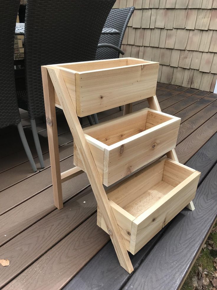 three wooden drawers sitting on top of a deck