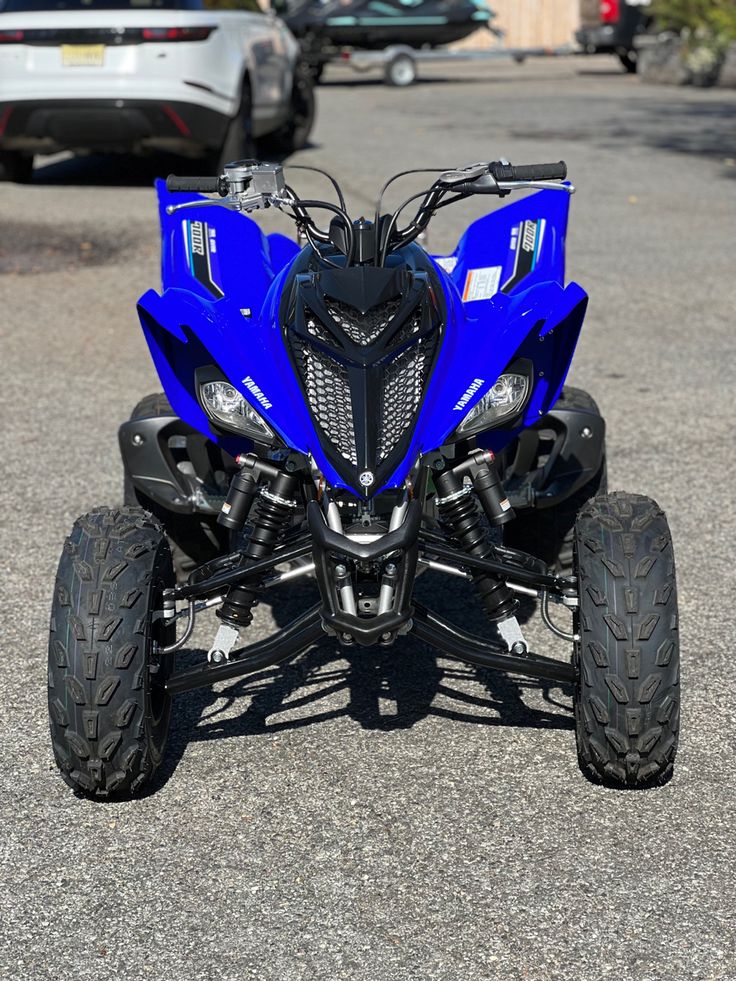 a blue four - wheeler is parked in the parking lot