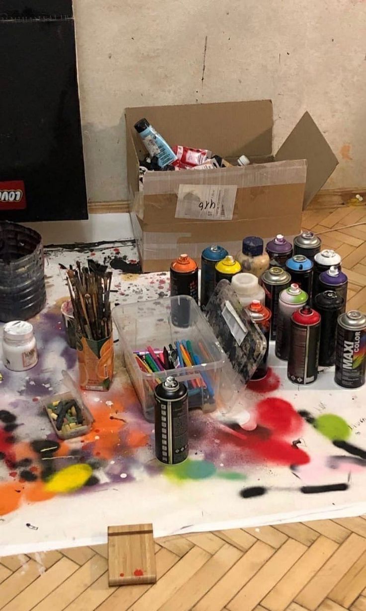 the table is covered with paint and other art supplies