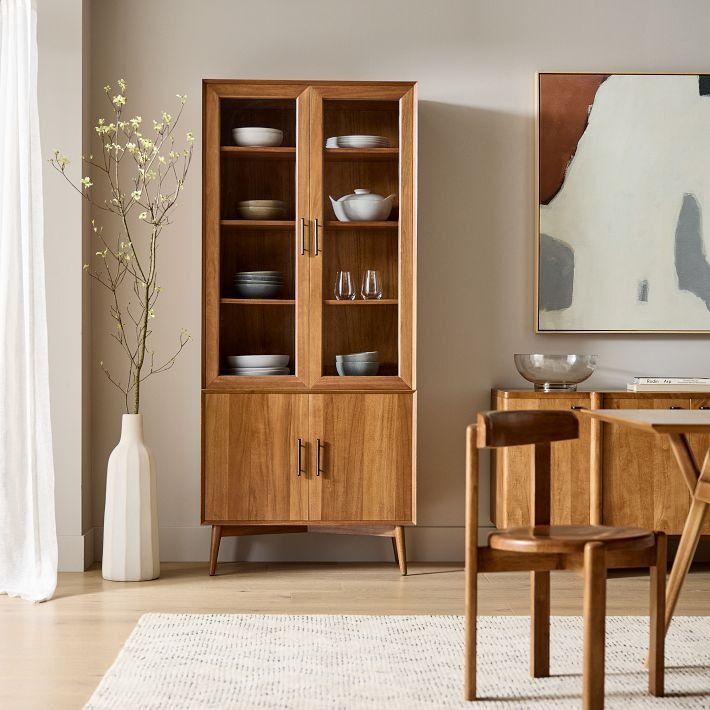 a wooden cabinet sitting next to a dining room table