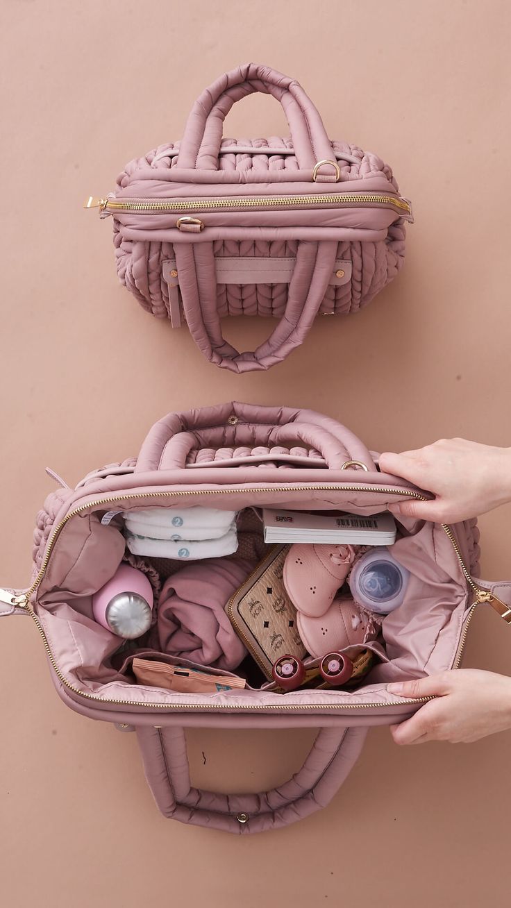 two women's hands holding an open pink purse