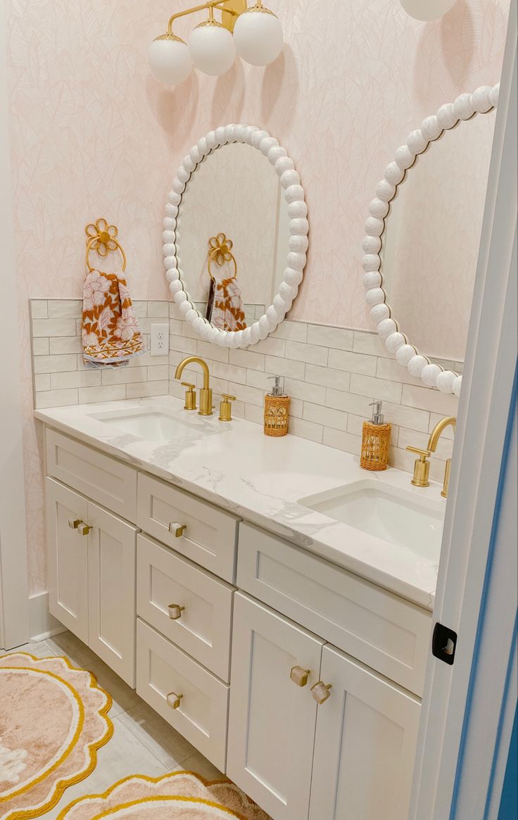 a bathroom with two sinks and three mirrors on the wall next to eachother