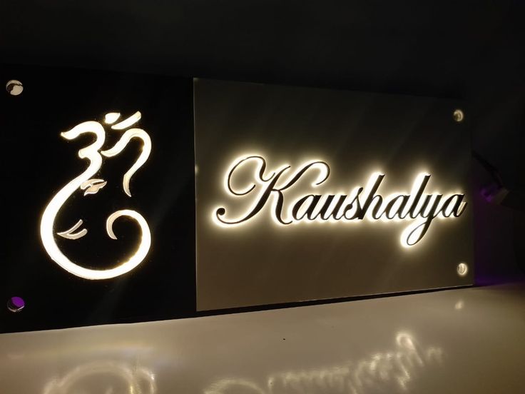 the illuminated sign for kaushalaya is lit up in black and white colors